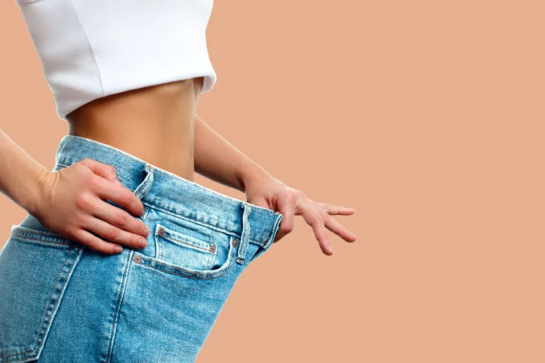 Close-up of a woman showing loose jeans after significant weight loss, representing success from a Weight Loss Program in South Ogden UT.