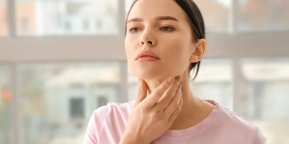 A woman gently touching her neck, representing thyroid function concerns in South Ogden, UT