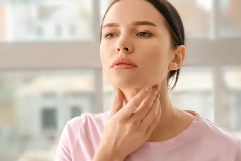 A woman gently touching her neck, representing thyroid function concerns in South Ogden, UT