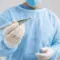 Healthcare provider in a clinical setting holding a hormone pellet with sterile tweezers before a hormone pellet therapy procedure.