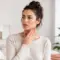 Woman experiencing low thyroid symptoms and touching her throat